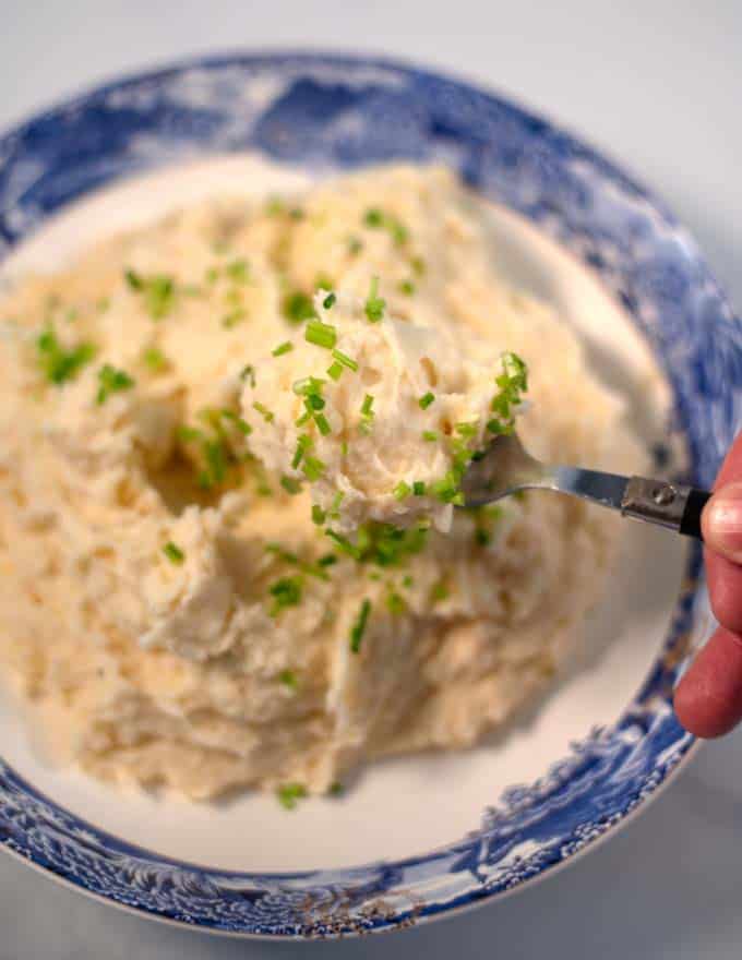 A spoon full of Mashed Potatoes and Cauliflower is lifted.