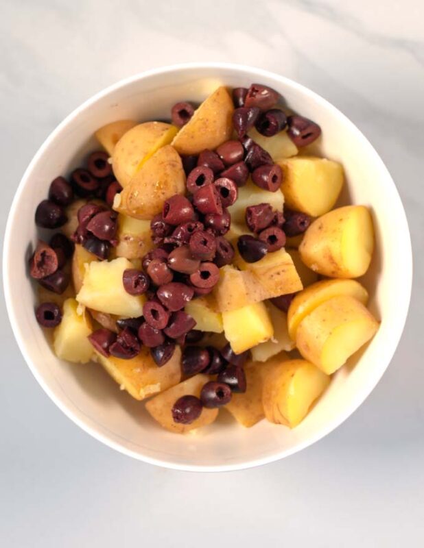 Potatoes and olives in a large bowl.