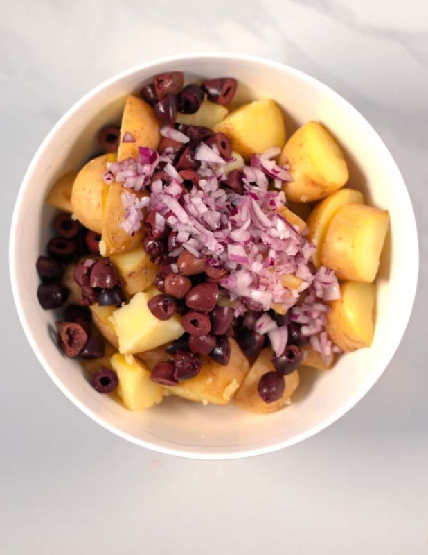 Finely diced red onions are added to the bowl.