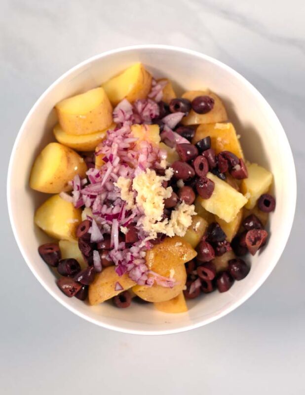 Garlic and seasoning are given to the Greek Lemon Potato Salad.