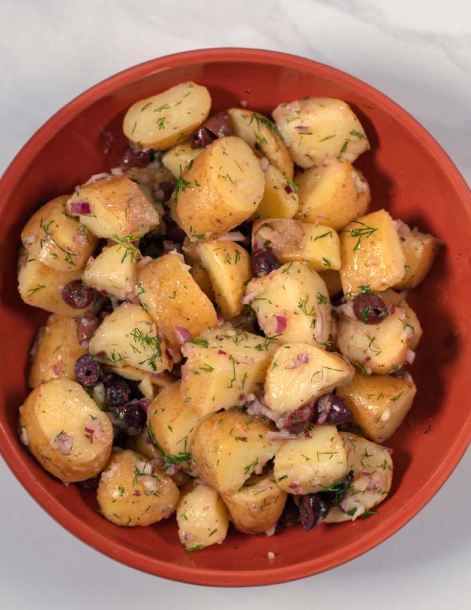 Serving of Greek Lemon Potato Salad on a brown plate.