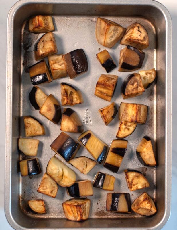 Oven-roasted eggplant cubes in a baking dish.