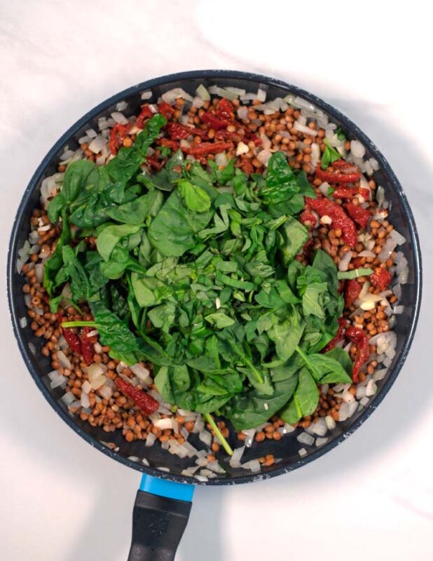 Basil and baby spinach are given to the pan.