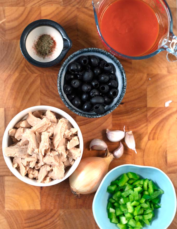Ingredients needed to make Spanish Chicken Stew are collected on a board.