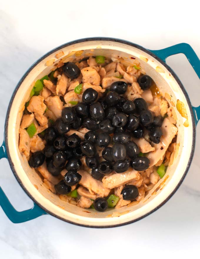 Olives are added to the pan.