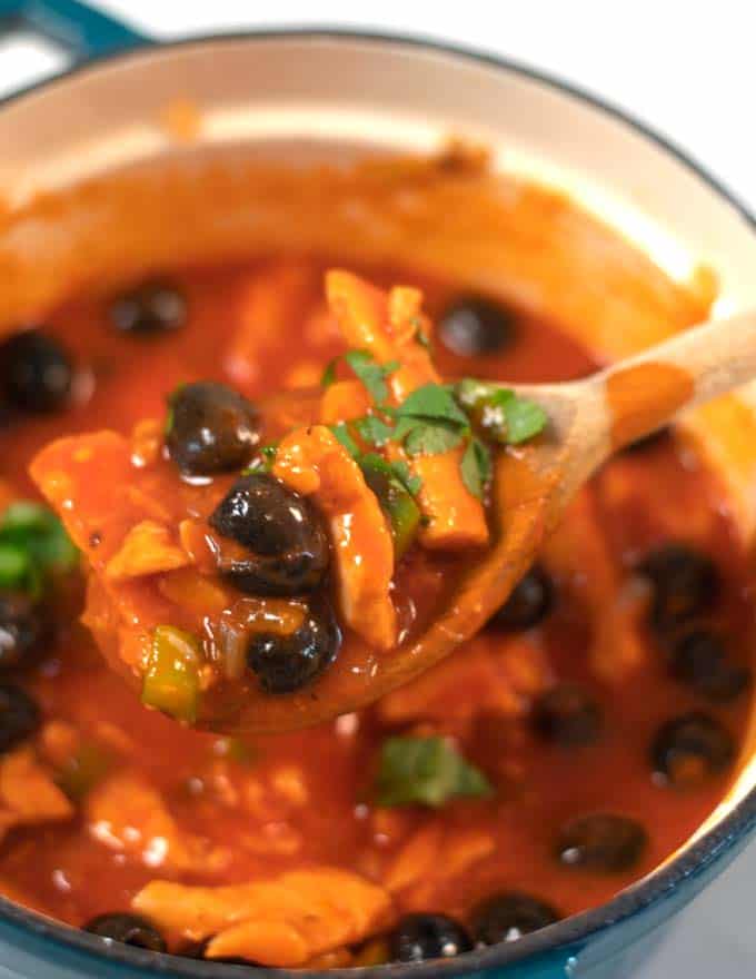 Closeup to a wooden spoon with Spanish Chicken Stew.