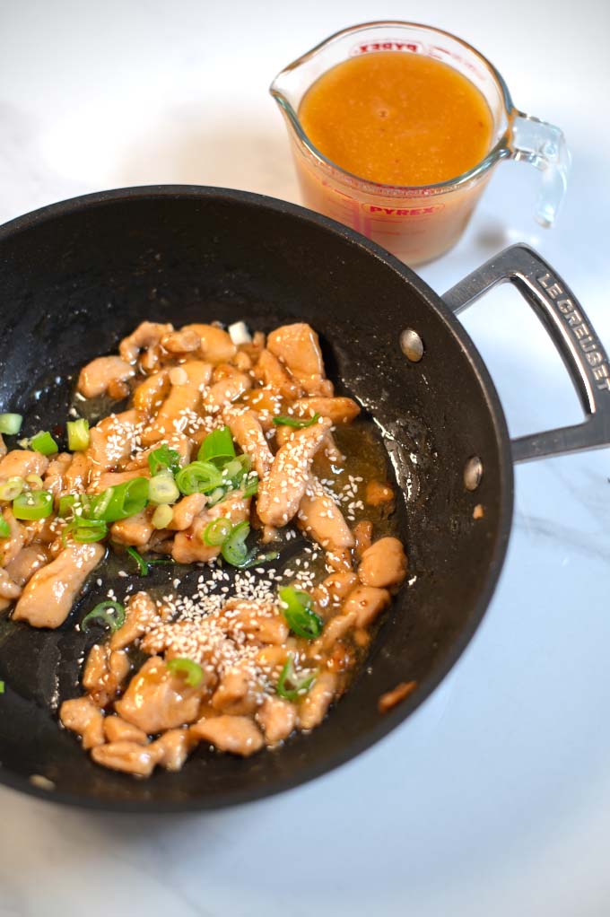 Chinese Orange Sauce is used to cook vegan chicken strips in a pan.