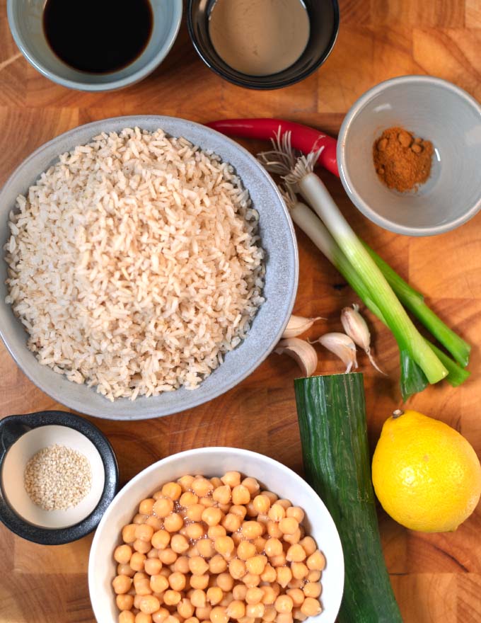 Ingredients needed to make Crispy Rice Salad are collected on a wooden cutting board.