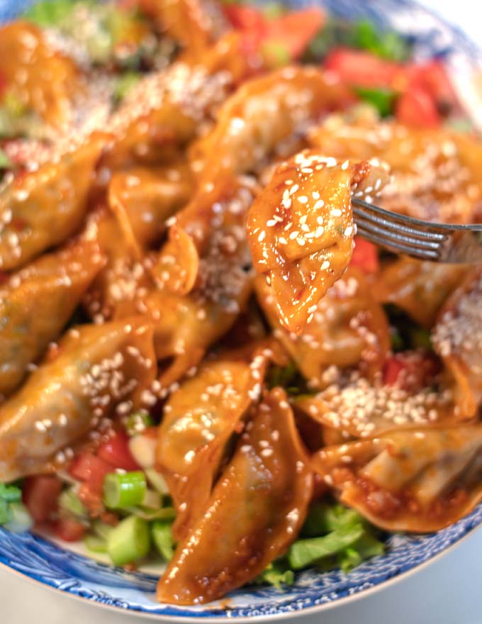 A fork lifts one dumpling from the Dumpling Salad.