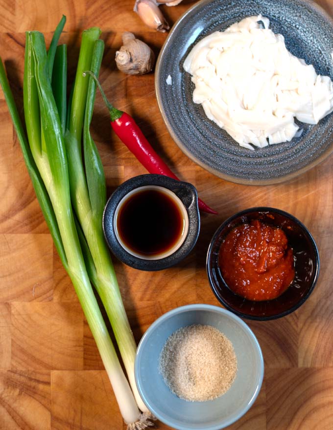 Ingredients needed to make Szechuan Noodles collected on a cutting board.