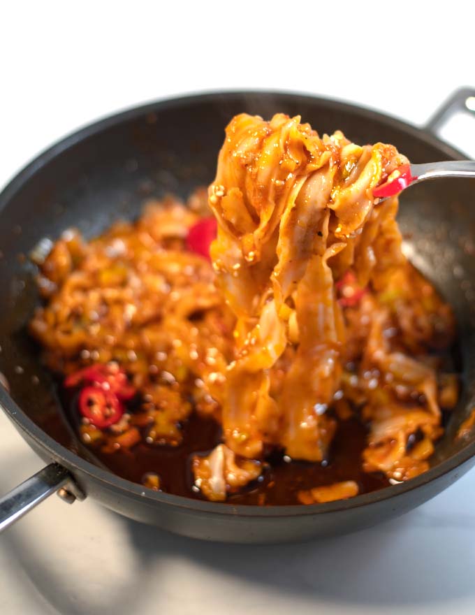 A fork lifts Szechuan Noodles from the pan.
