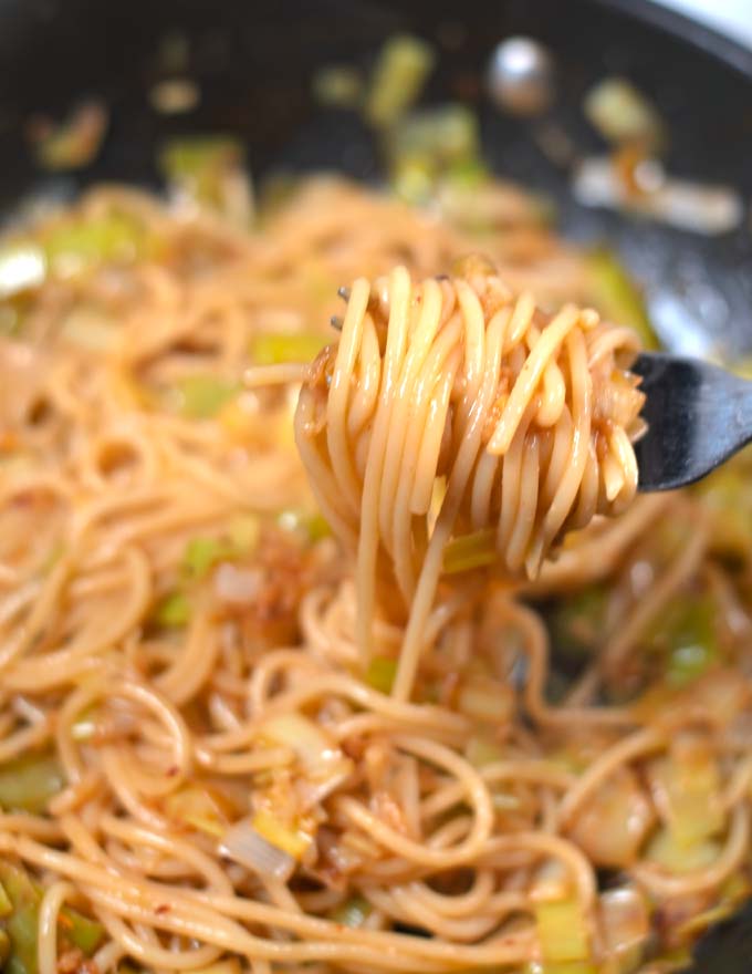 A fork lifts Miso pasta from the pan.