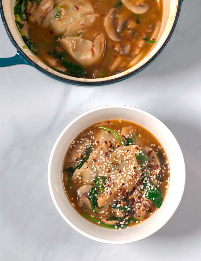 A serving of Potsicker Soup in a white serving bowl with the pot in the background.