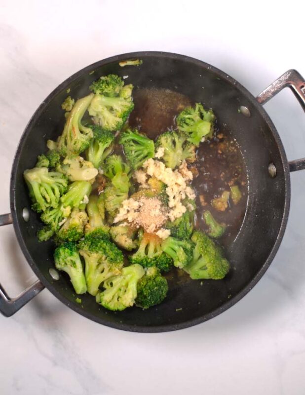 Seasonings and liquid ingredients are added to the broccoli.