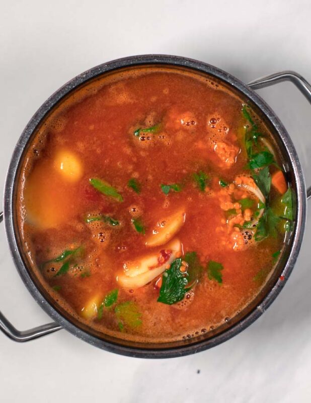Adding vegetable broth to the Turkish Lentil Soup.